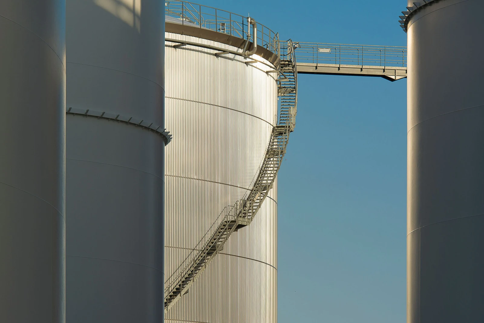 Real photograph of industrial silos with steel stairs and access platforms